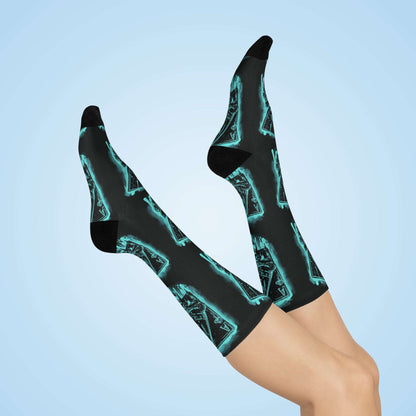 Pair of crew socks with a glowing blue neon aces of spades design held in skeletal hands. The socks are worn on model's feet with dark gray soles and a dark gray background. (Keywords: poker socks, aces socks, pocket aces socks, neon socks, card game socks, gambling socks, casino socks, crew socks, comfortable socks)